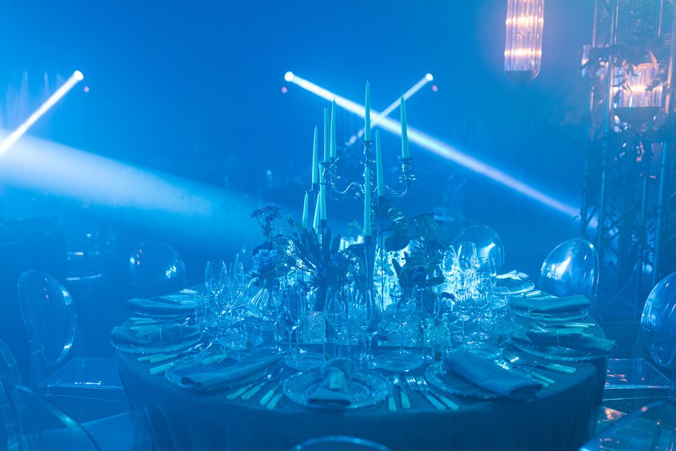 Iluminación de color azul dentro de la carpa de circo durante la boda.