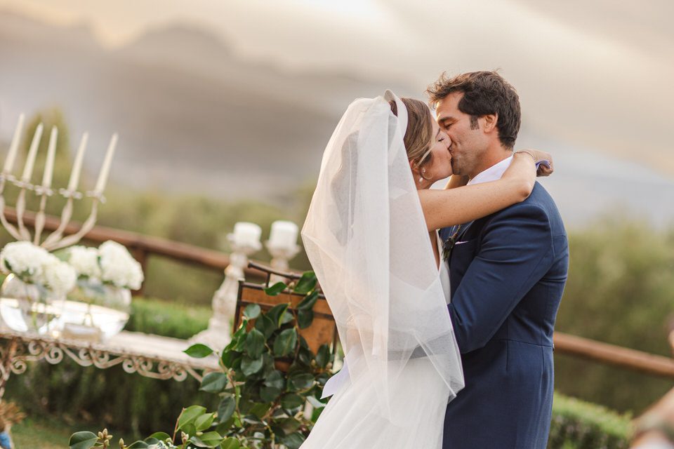 Beso de novios al atardecer en el campo